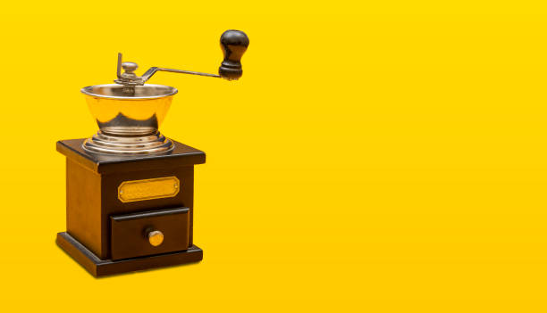 istock Vintage coffee crushing grinder closeup view on yellow banner background 1284059202
