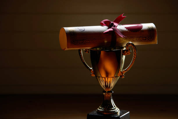 istock trophy and roll of certificate on the wood background 1284059393