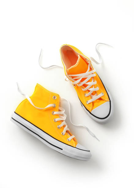 chaussures en toile jaune - untied pair sports shoe shoe photos et images de collection