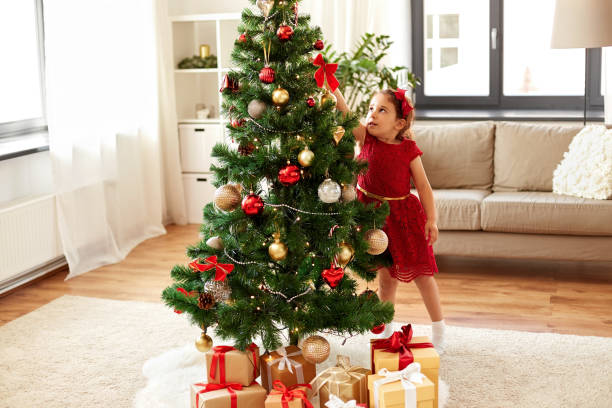 istock little girl decorating christmas tree at home 1284062046