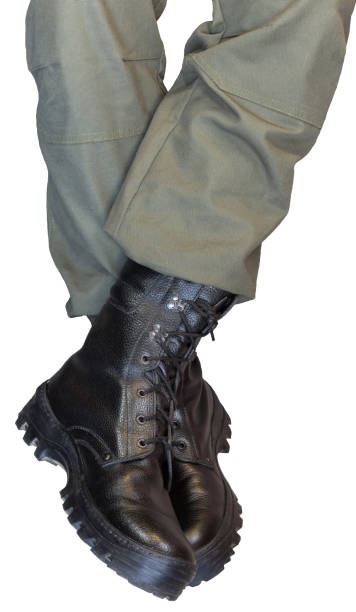 istock Legs in army khaki pants and military boots 1284063690