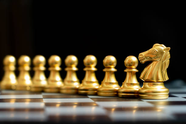 istock Gold knight chess piece stand with pawn on black background (Concept of teamwork, management) 1284063829