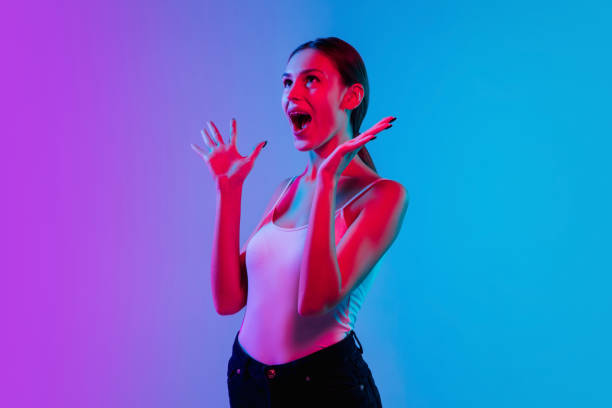istock Young caucasian woman's portrait on gradient blue-purple studio background in neon light 1284065029