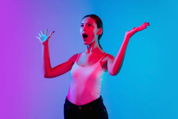 istock Young caucasian woman's portrait on gradient blue-purple studio background in neon light 1284065049