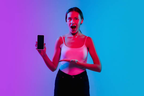 istock Young caucasian woman's portrait on gradient blue-purple studio background in neon light 1284065060