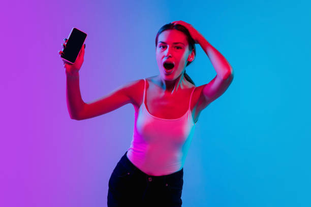 istock Young caucasian woman's portrait on gradient blue-purple studio background in neon light 1284065068