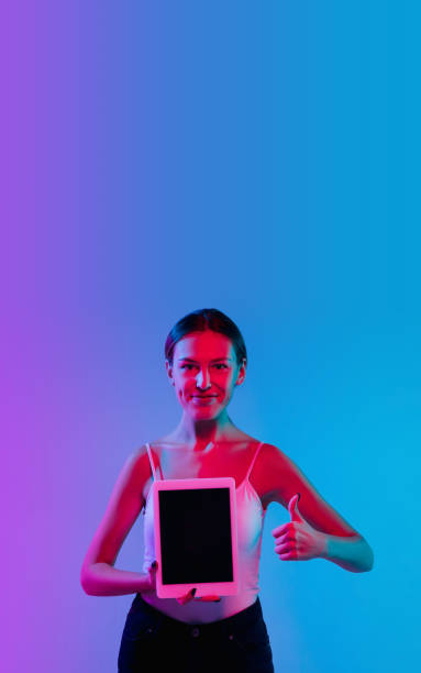 istock Young caucasian woman's portrait on gradient blue-purple studio background in neon light 1284065071