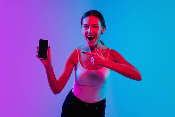 istock Young caucasian woman's portrait on gradient blue-purple studio background in neon light 1284065072