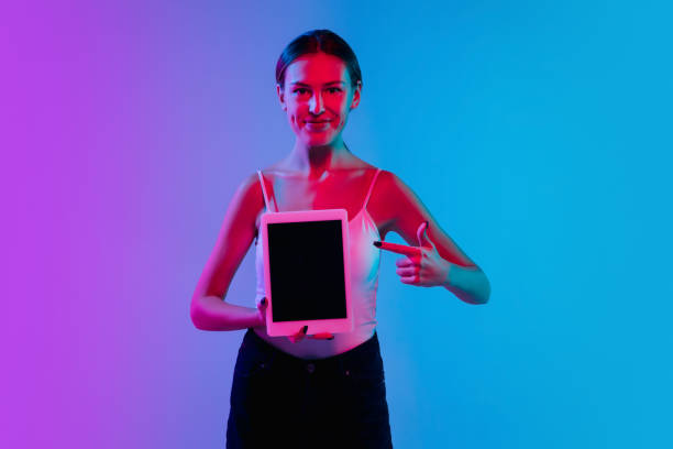 istock Young caucasian woman's portrait on gradient blue-purple studio background in neon light 1284065078