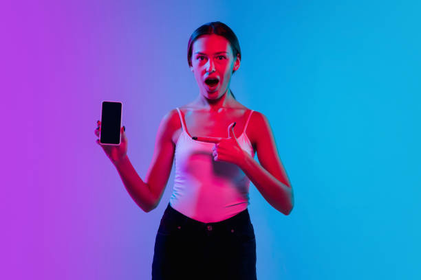 istock Young caucasian woman's portrait on gradient blue-purple studio background in neon light 1284065083