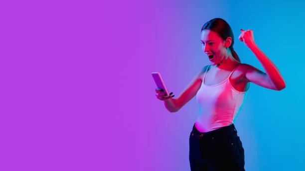 istock Young caucasian woman's portrait on gradient blue-purple studio background in neon light 1284065091