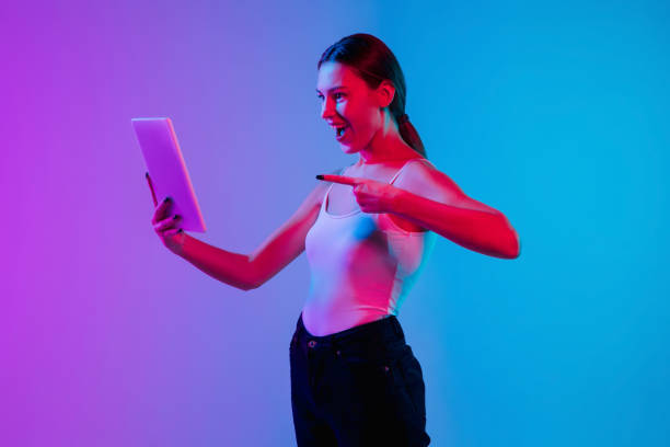 istock Young caucasian woman's portrait on gradient blue-purple studio background in neon light 1284065101