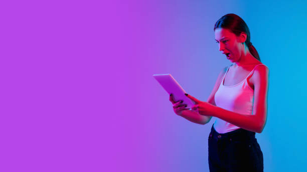 istock Young caucasian woman's portrait on gradient blue-purple studio background in neon light 1284065103