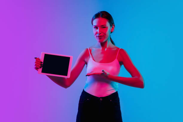 istock Young caucasian woman's portrait on gradient blue-purple studio background in neon light 1284065105