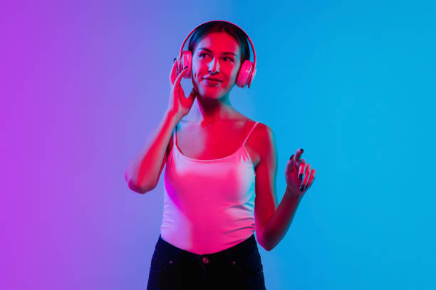 istock Young caucasian woman's portrait on gradient blue-purple studio background in neon light 1284065106