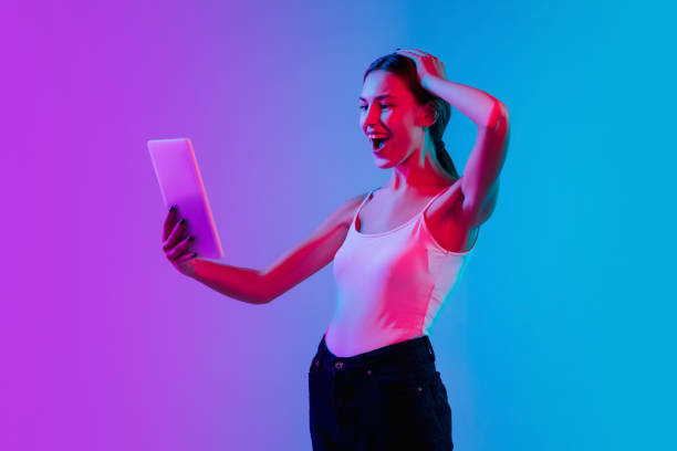 istock Young caucasian woman's portrait on gradient blue-purple studio background in neon light 1284065109