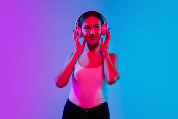 istock Young caucasian woman's portrait on gradient blue-purple studio background in neon light 1284065113