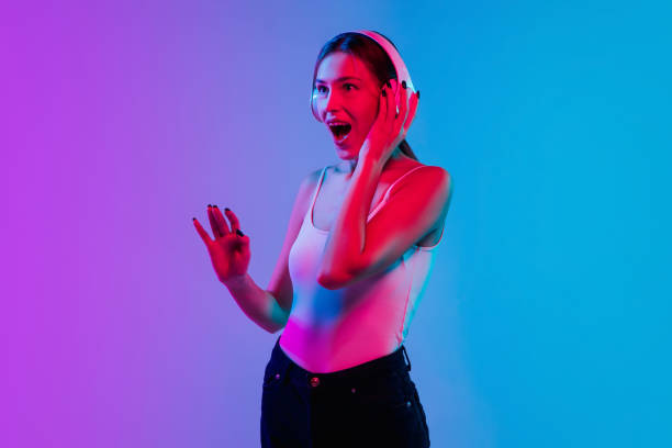 istock Young caucasian woman's portrait on gradient blue-purple studio background in neon light 1284065119