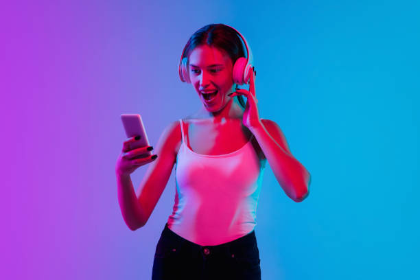 istock Young caucasian woman's portrait on gradient blue-purple studio background in neon light 1284065127
