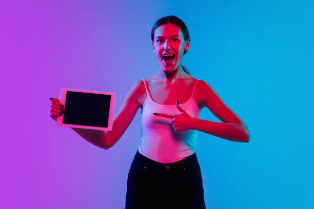 istock Young caucasian woman's portrait on gradient blue-purple studio background in neon light 1284065143