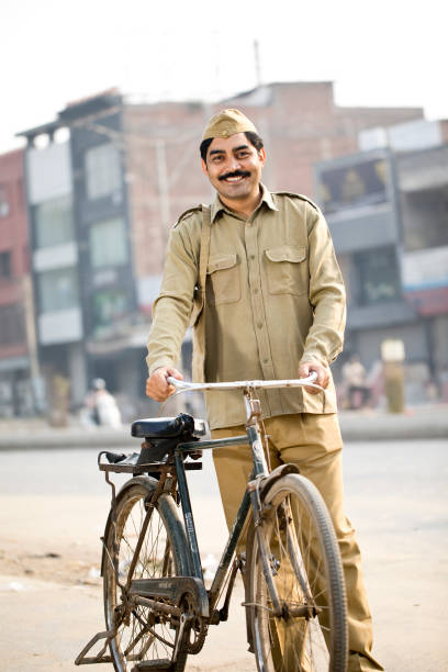 istock Postal worker with bicycle on street 1284065435