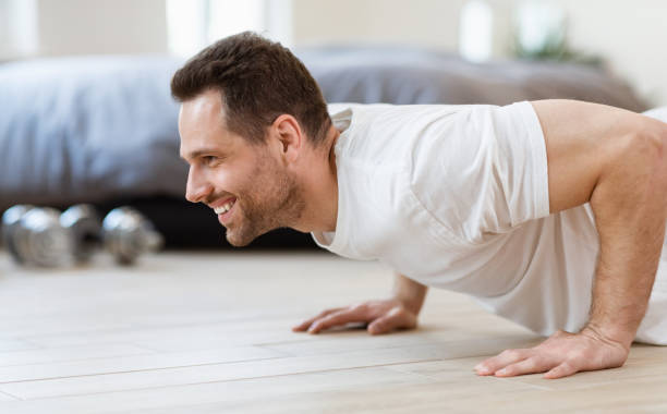 istock Sporty Man Doing Plank Exercise On Floor Training At Home 1284065516