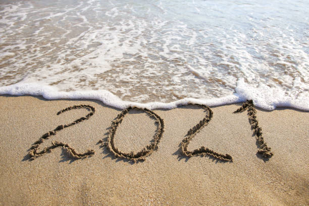 istock 2021 year written on sandy beach sea. Top view. Flat lay. 1284066560