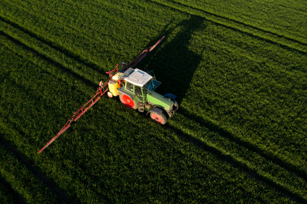 istock Tractor spraying pesticides, aerial view 1284066897