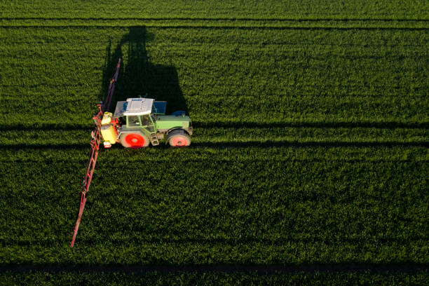istock Tractor spraying field, aerial view 1284067020