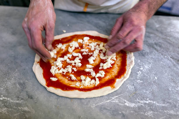 istock Cooking pizza. Pancake for pizza smeared with tomato sauce lies on the table. 1284067617