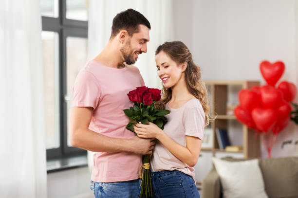 istock couple with flowers at home on valentines day 1284069011