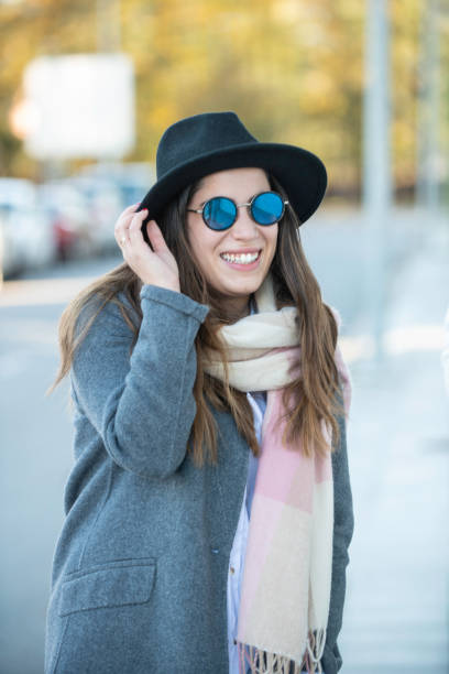 istock young lady laughing and holding her hat 1284069259