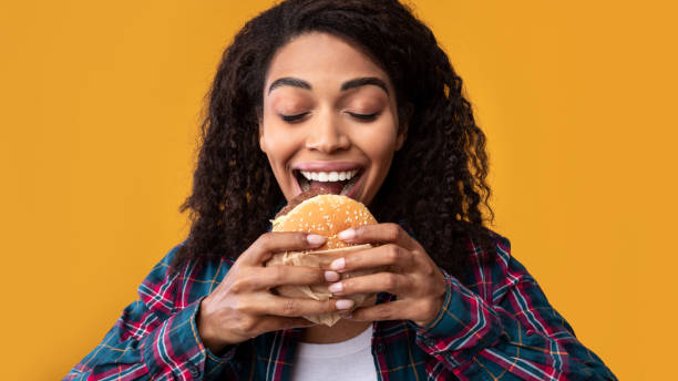 istock Hungry African American Lady Eating Burger At Studio 1284070503