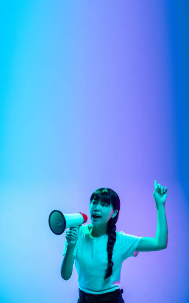 istock Young asian woman's portrait on gradient blue-purple studio background in neon light 1284071110