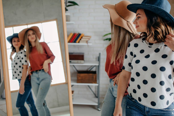 istock Two best friends playing with hat in front of mirror 1284072424