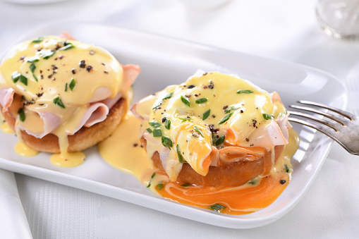 Breakfast. Best Eggs Benedict - fried English bun, ham, poached eggs and delicious Hollandaise   butter sauce