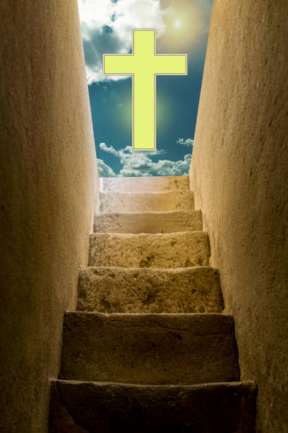 istock An old staircase leading from darkness to light and sky with a cross 1284073142