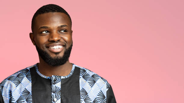 istock Positive black guy in african shirt looking at copy space 1284073385