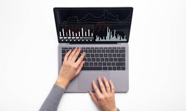 istock Female hands typing on laptop computer with business financial graphics on screen 1284074529