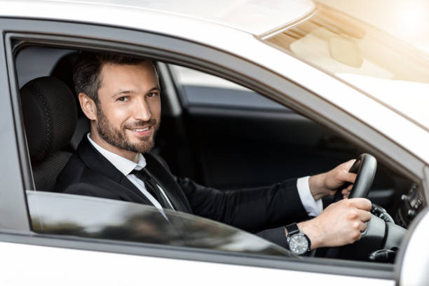 istock Cheerful successful businessman looking through car window 1284075107