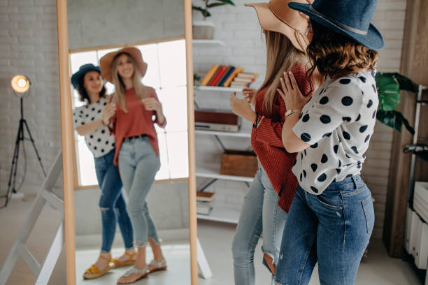 istock Two best friends playing with hat in front of mirror 1284076063