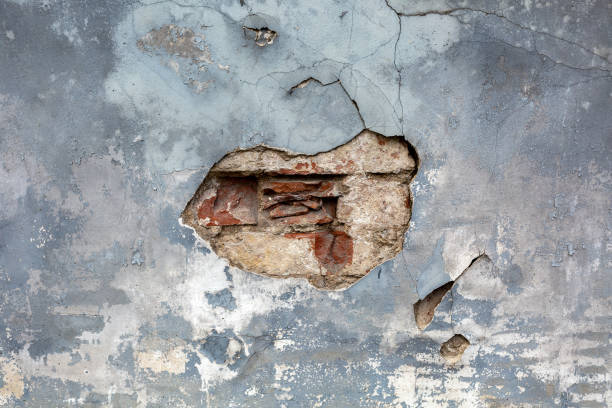 istock Background with old brown cracked stucco on a gray wall texture 1284077803