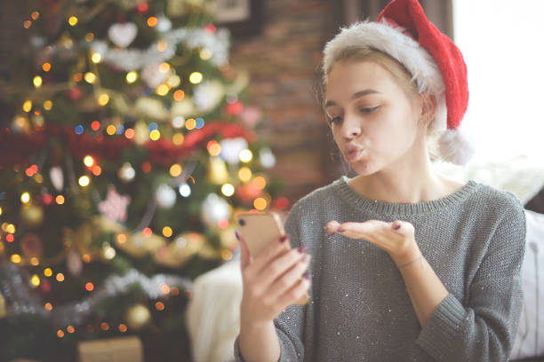 istock young woman in christmas interior with smartphone (online dating) 1284079407