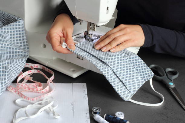 istock Young woman making protective face mask at home. 1284079557