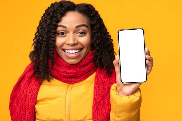 istock Joyful African Lady Showing Phone Screen To Camera, Yellow Background 1284082262