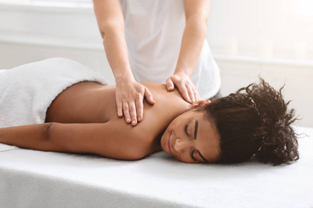 istock Female therapist rubbing sleeping african american lady back 1284084173