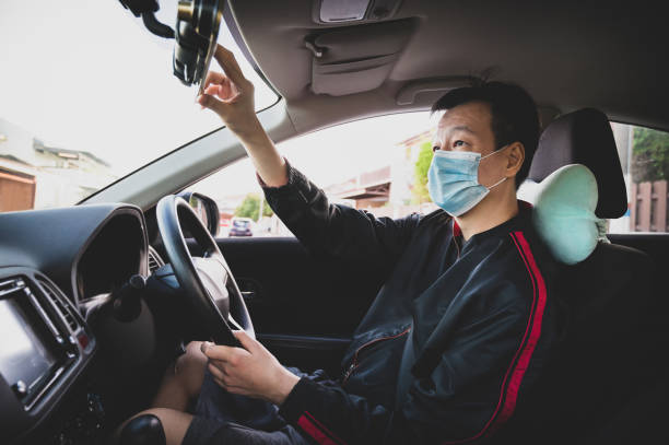 istock Asian E-hailing driver with protective face mask checking on rear mirror and get ready to start work 1284084351
