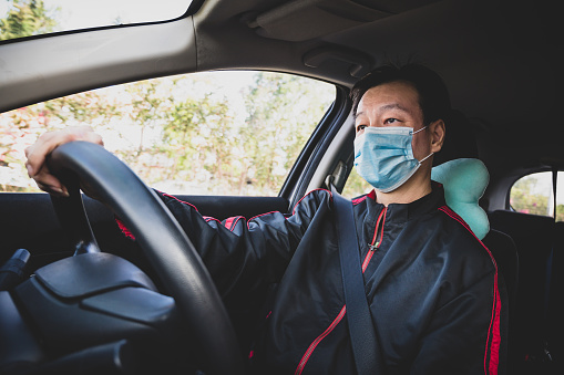Hombre adulto medio conduciendo en carretera con mascarilla protectora para evitar enfermedades infecciosas durante la crisis mundial de la pandemia photo