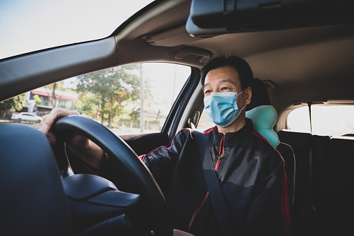 Retrato del conductor asiático de E-hailing con máscara protectora en la carretera photo