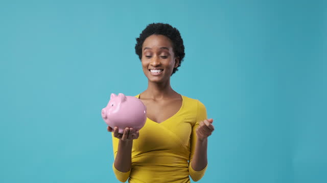Woman inserting coin into piggy bank